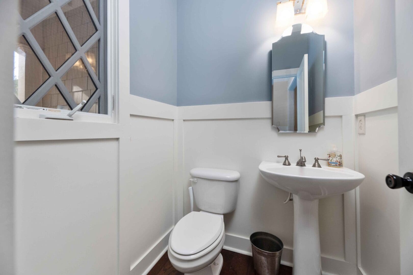 A bathroom with blue walls and white trim.